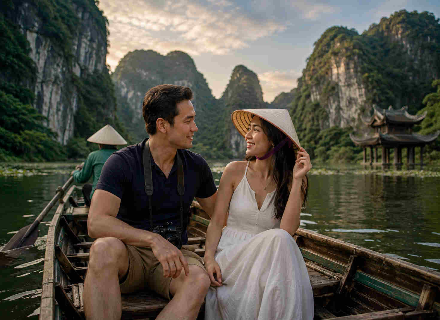 Couple taking a wooden boat through Trang An in Ninh Binh Vietnam