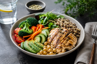 Healthy lunch bowl with grilled chicken, vegetables, quinoa, and avocado