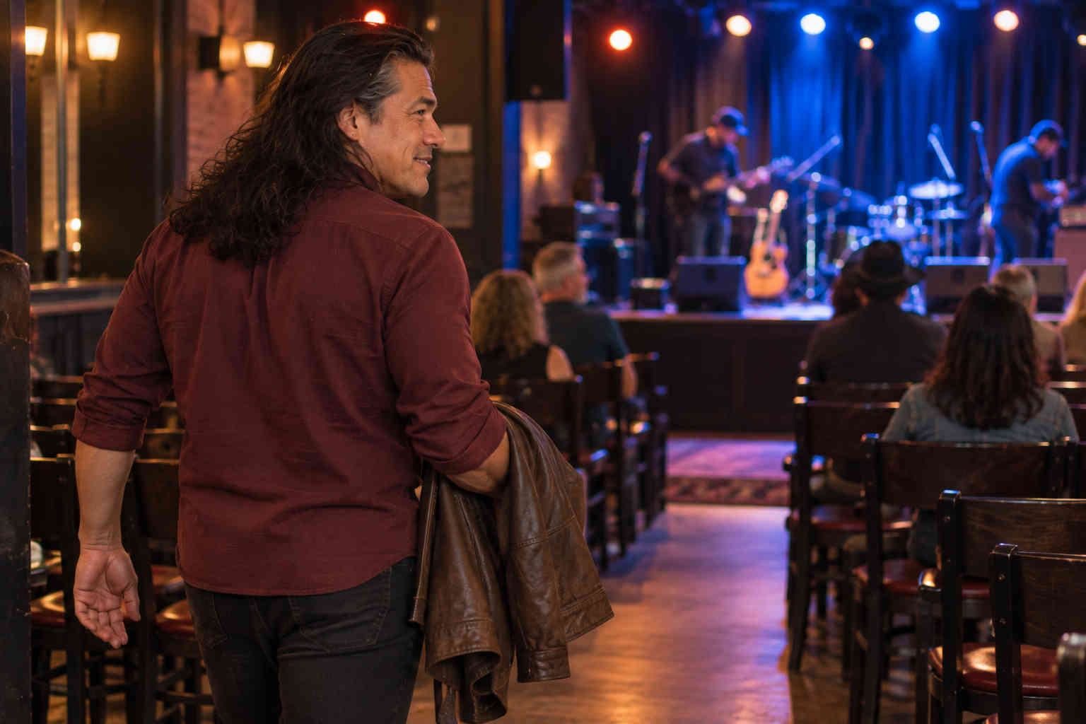 Man entering a small live music venue alone and looking toward the stage