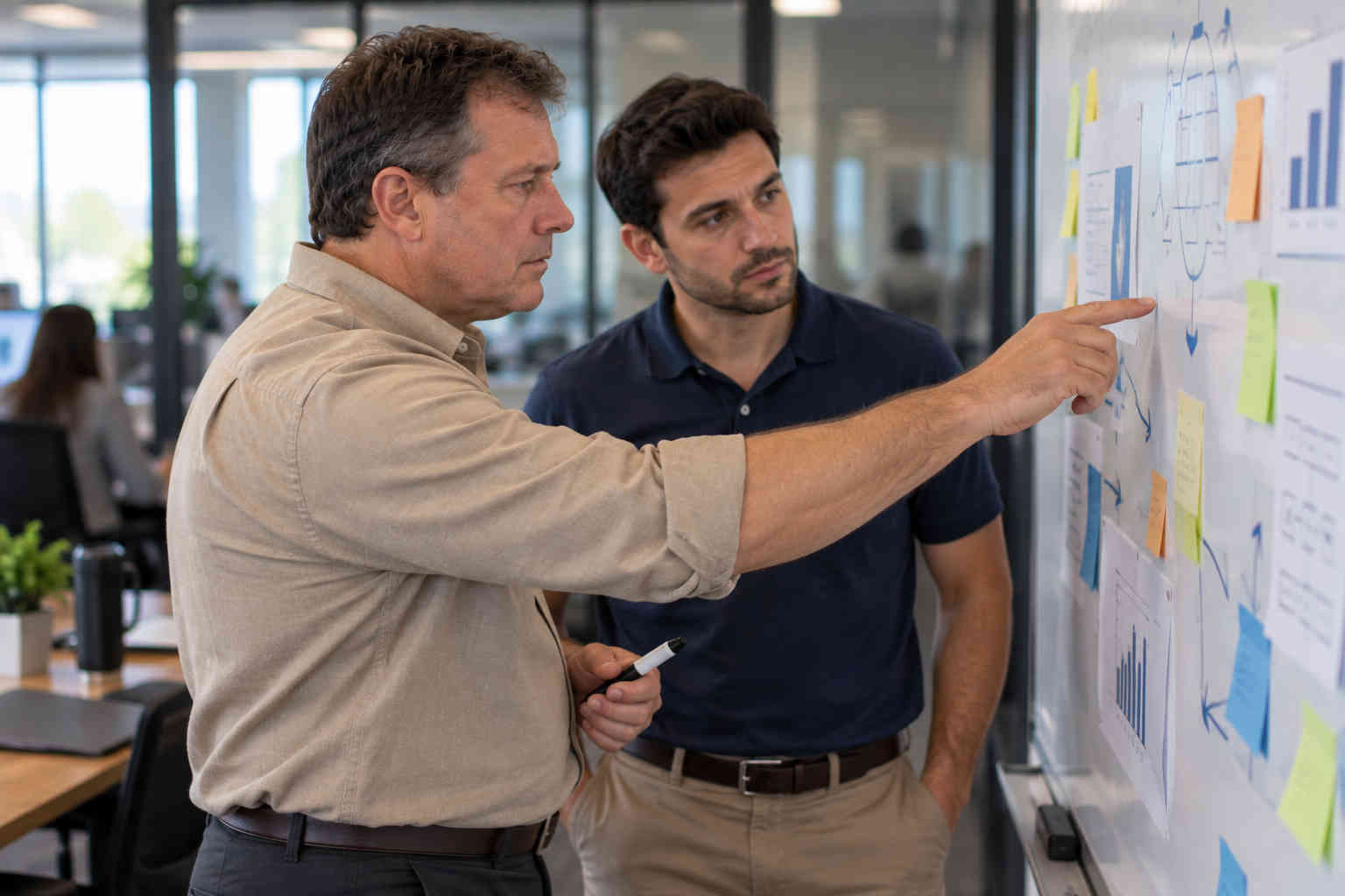 Man working with a younger colleague and recognizing the career skills he has built
